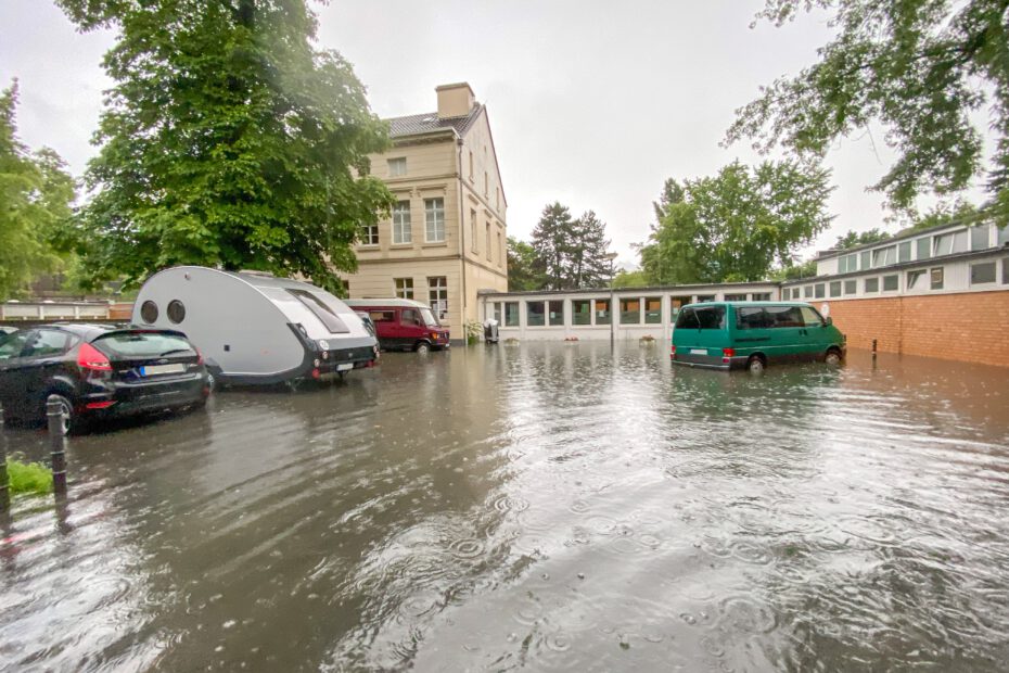 Der Parkplatz des Schulgebäudes "Lindweiler Hof" während des verheerenden Hochwassers am 14. Juli 2021. Die Künstlerinnen und Künstler in Köln-Bickendorf setzen sich für eine Retentionsmulde "Kradepohl" als Hochwasserschutz ein.
