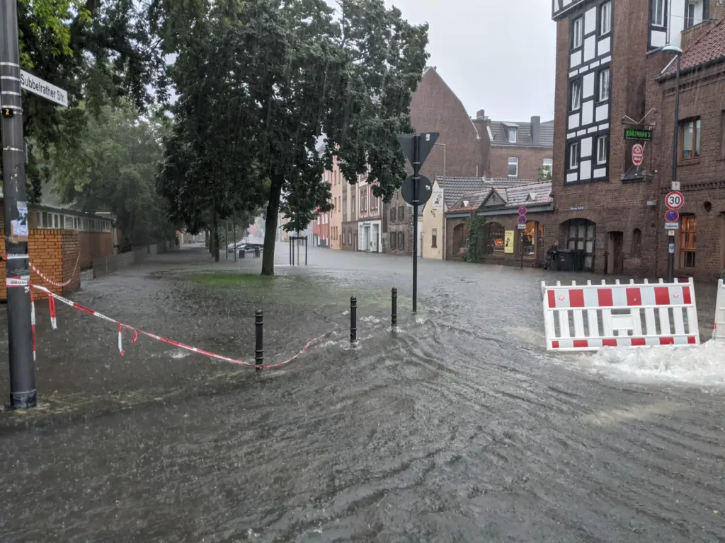 Bild von der 2021 völlig überfluteten Rochusstraße in Bickendorf auf den Weinturm und die umliegenden Gebäude.