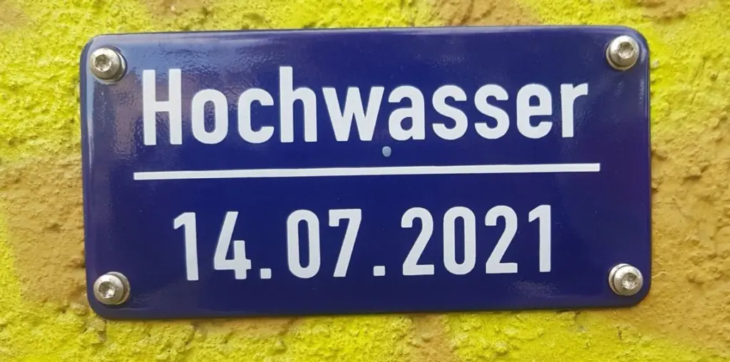 Emaille-Schild am Haus Teichstraße 2 als Gedenken an den Höchststand des Hochwassers vom 14.07.2021 in Köln-Bickendorf.